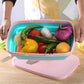 Folding plastic cutting board holding vegetables with included knife, teal tray and pink base