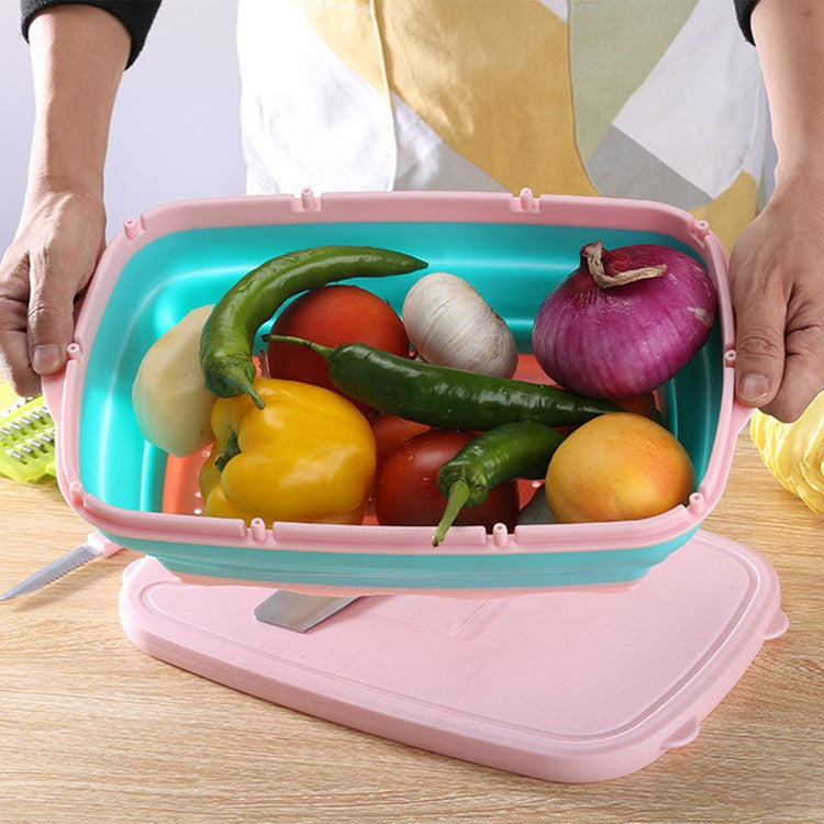 Folding plastic cutting board holding vegetables with included knife, teal tray and pink base