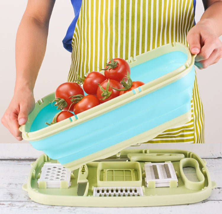 Folding plastic cutting board with blue tray being lifted, holding tomatoes and peppers