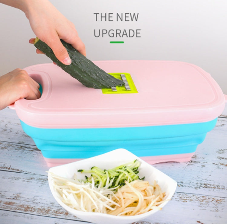 Folding plastic cutting board with mounted grater on top, pink lid and blue base