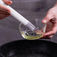 Silicone pastry brush applying oil to a bowl