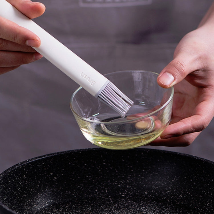 Silicone pastry brush applying oil to a bowl