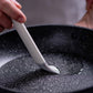 Gray silicone brush bristles touching a nonstick pan