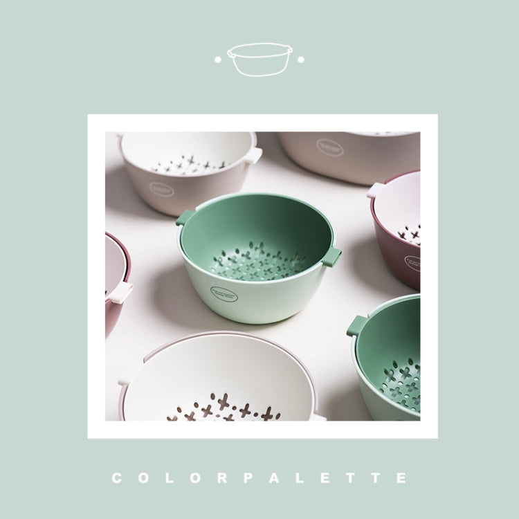 Green plastic vegetable drain basket among pastel bowls