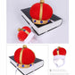 Red plush pet crown hat with gold band, blue gem decorations, and white elastic straps shown on stand.