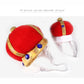 Pair of red plush pet crown hats with gold trim and blue jewel buttons; white elastic chin ties.