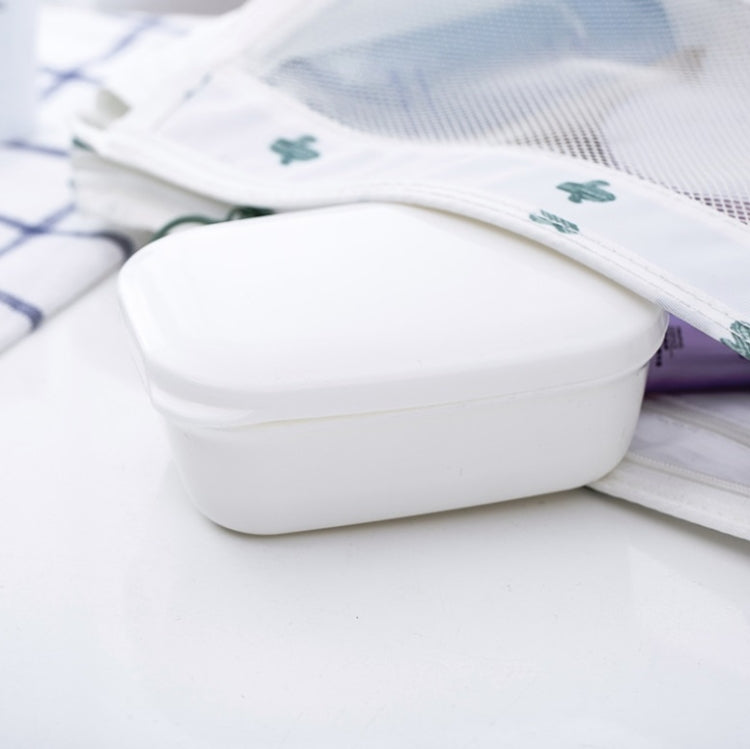 White plastic soap holder with snap lid resting on folded cloth