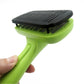 Green pet grooming comb with black bristle brush head held in hand