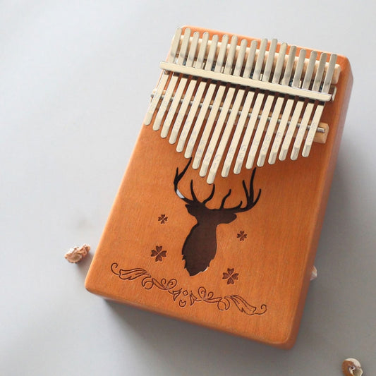 Wooden 17-tone kalimba with deer silhouette, engraved leaves, and white metal tines