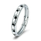 Sterling silver paw print ring with black enamel footprints, angled studio view