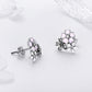 Sterling silver flower stud earrings with pink enamel petals, CZ details, and stud back