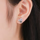 Small sterling silver pink enamel flower stud earrings with cubic zirconia on ear