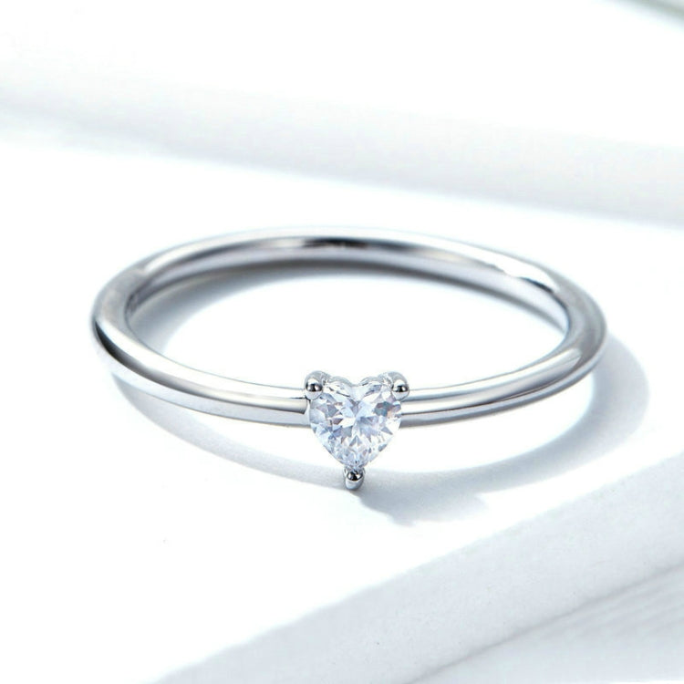 Heart-shaped clear CZ solitaire ring with slim silver band, top view