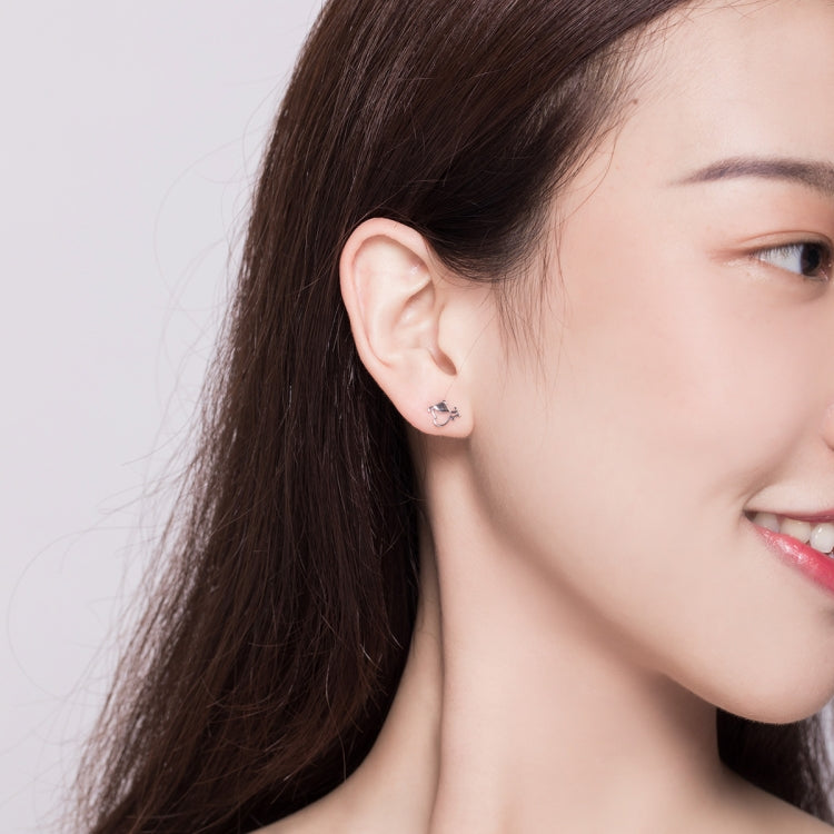 Sterling silver dog bone stud earrings on model, close-up at ear