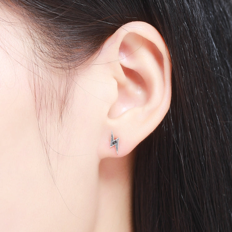 Sterling silver lightning bolt stud earring on model ear with black accents