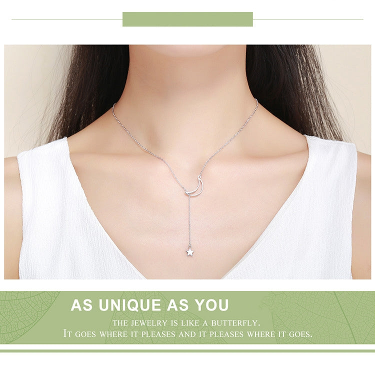 Sterling silver moon and star pendant necklace worn at the neckline, fine chain