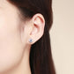 Round zircon stud earrings in sterling silver on ear, close-up