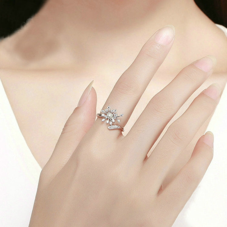 Dainty silver dandelion ring on hand with yellow center and clear CZ stones
