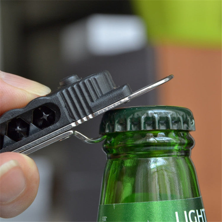 Mini screwdriver bottle opener bit hooked on a green bottle cap