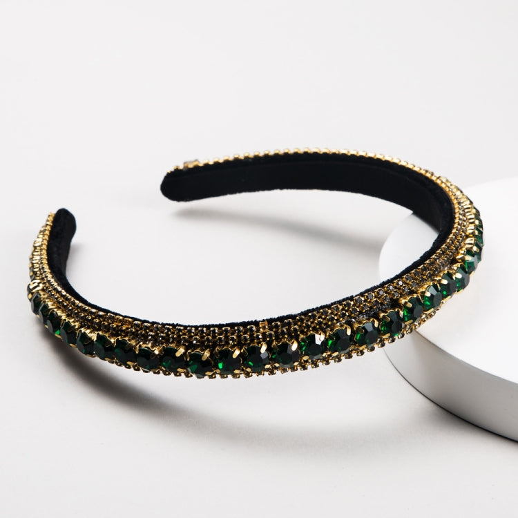Black velvet rhinestone headband with gold trim and green/black stones
