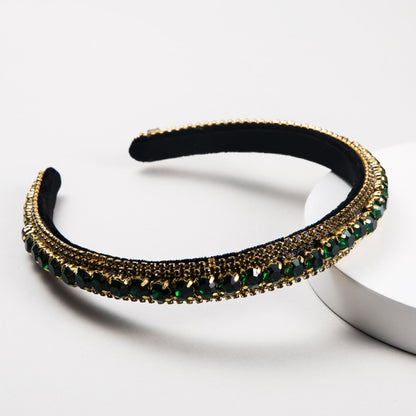 Black velvet rhinestone headband with gold trim and green/black stones