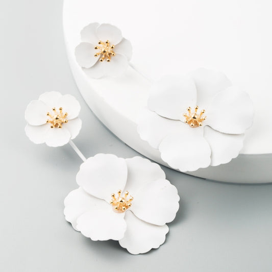 White flower drop earrings with gold-tone centers and long dangling stems, alloy design