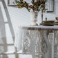 Close-up of white lace tablecloth with embossed floral scroll pattern