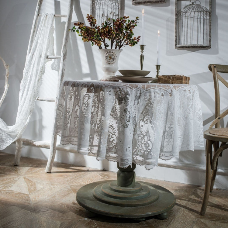 White round lace tablecloth covering dining table, scalloped lace border