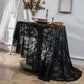 Black round lace tablecloth draped on table, intricate damask lace design