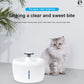 White pet water dispenser with blue indicator light beside a gray cat