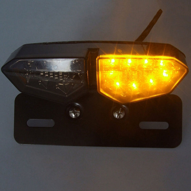 Motorcycle LED tail light with amber right lamp glowing and dark left lens