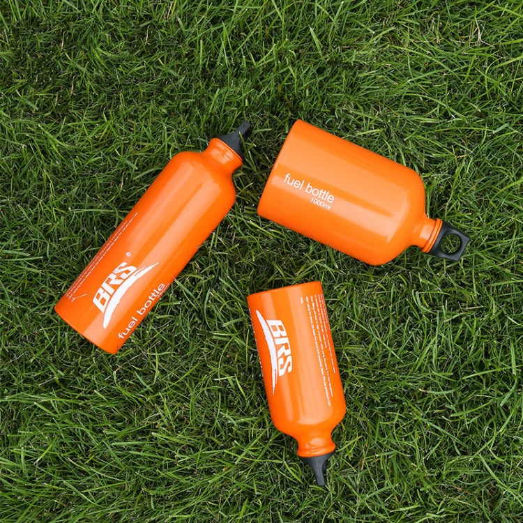 Orange fuel bottles on grass, black caps and side labels visible.