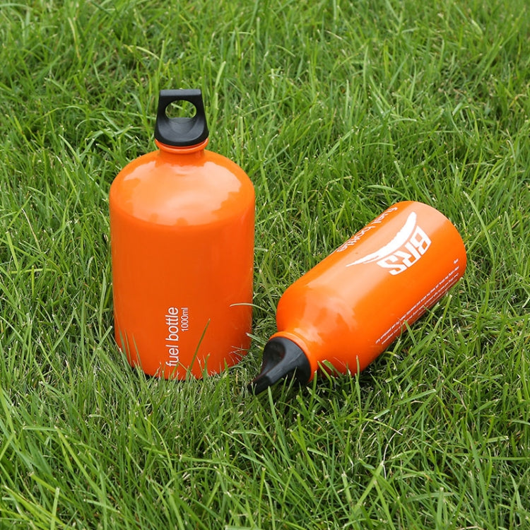 Orange fuel bottle with black cap and matching bottle beside it on grass.