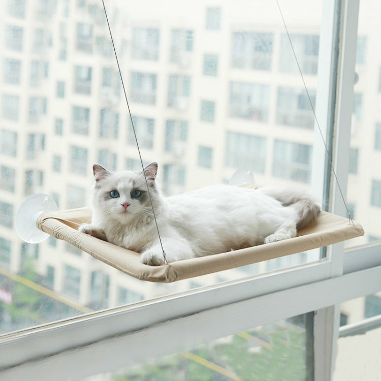 Cat lounging on window suction cup hammock with tan fabric bed