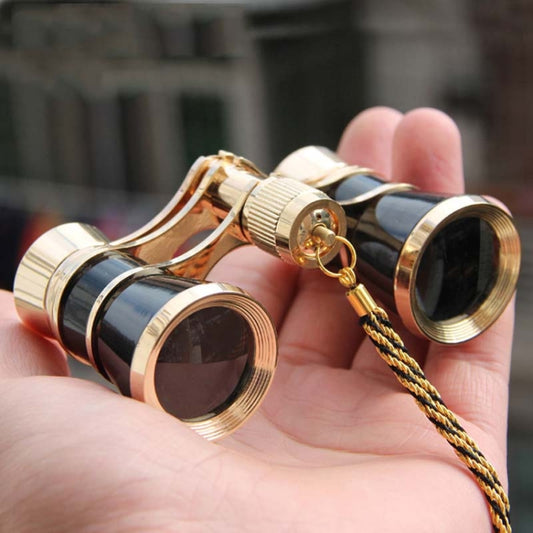 Classical opera binoculars with gold trim, black barrels, and braided carrying chain