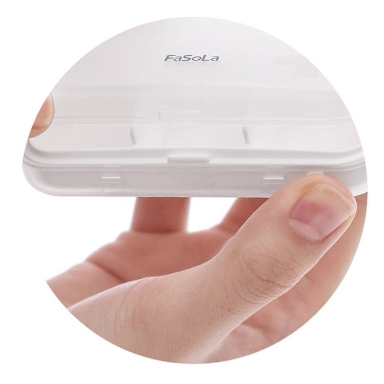Portable white pill box lid close-up with translucent window and compartment divider details