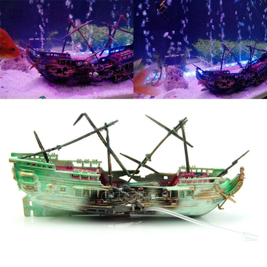 Toy shipwreck aquarium ornament with dark hull, green masts, and ropes