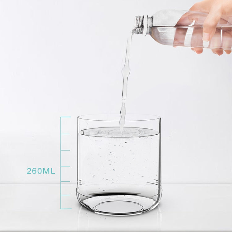 Clear humidifier water tank cup being filled with water, with volume markings