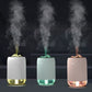 Car humidifiers in pink, turquoise, and white emitting mist from the top nozzles