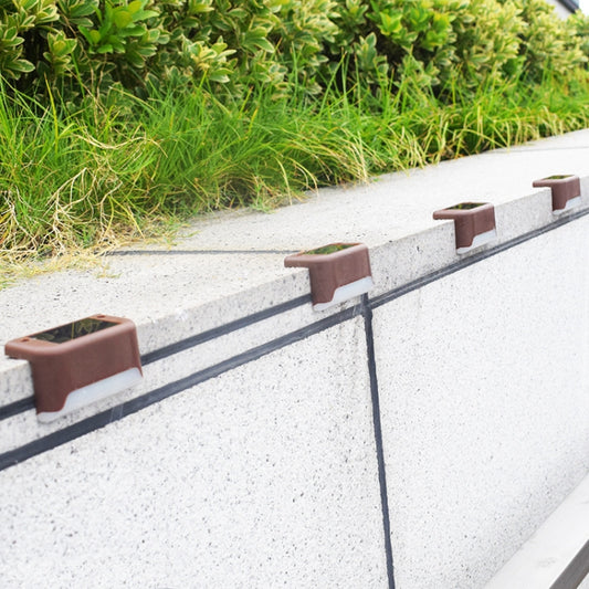 Brown solar LED step lights mounted along a concrete garden border