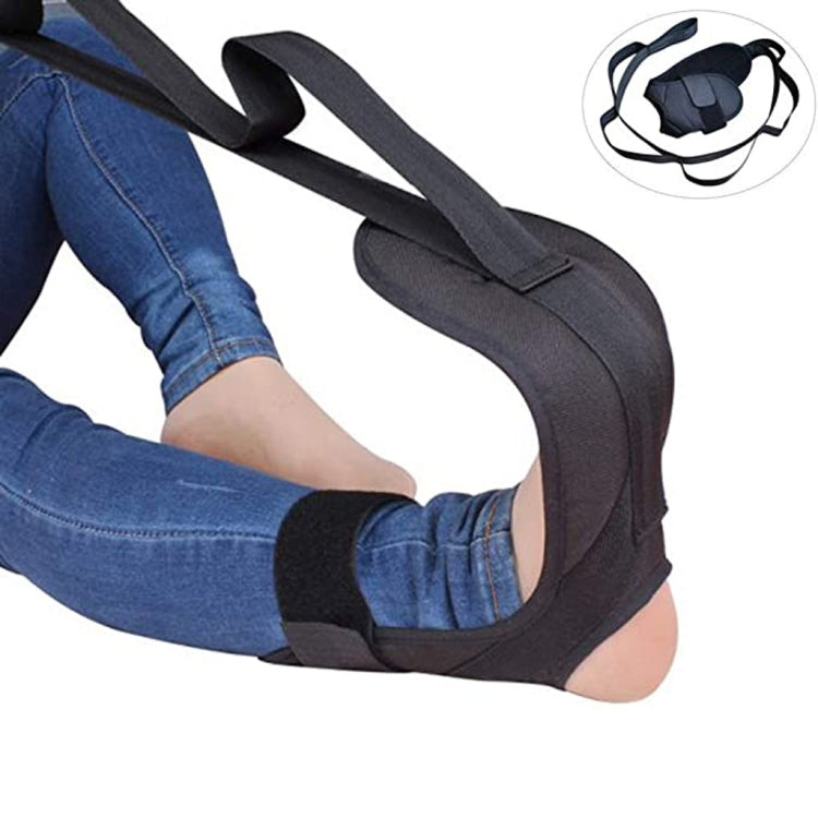 Black yoga stretching belt with loop for feet, used for leg stretch.