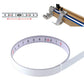 Self-adhesive steel measuring tape with circular loop and printed centimeter scale, straight ruler scale close-up