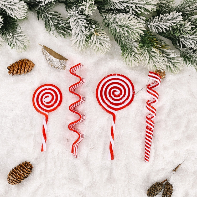 Group of red and white swirled lollipop and wavy candy Christmas ornaments on snow