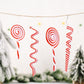Red and white candy spiral Christmas ornaments strung on a twine banner