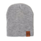 Gray knit baby beanie with folded cuff and leather patch label on side