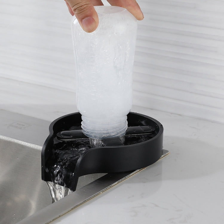 Black cup washer base with a clear cup under overhead water spray