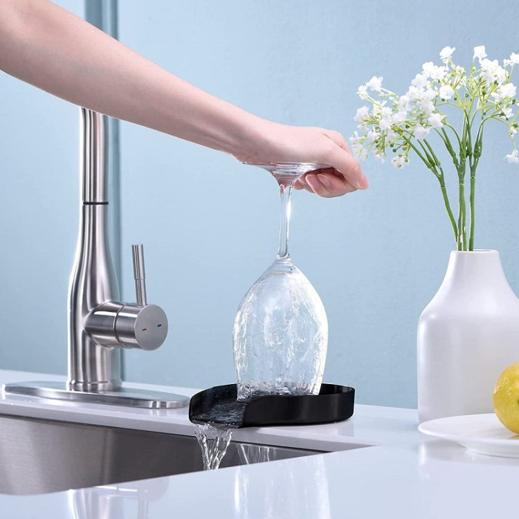 Black cup washer base with a glass bottle under a steady water spray