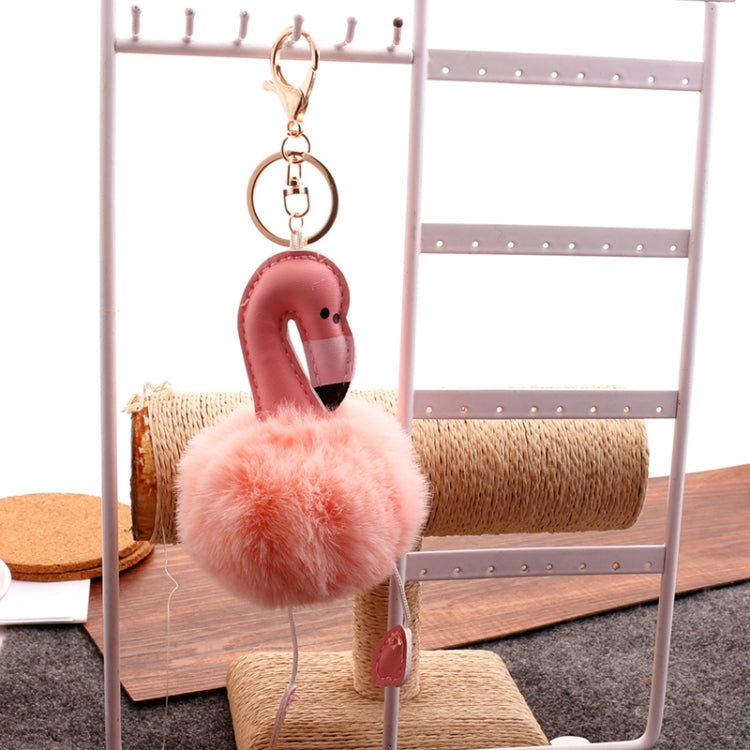 Flamingo plush keychain pendant with pink body and fluffy light-orange pom pom, dangling feet