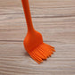 Orange silicone basting brush with fan-shaped bristle head and long handle.