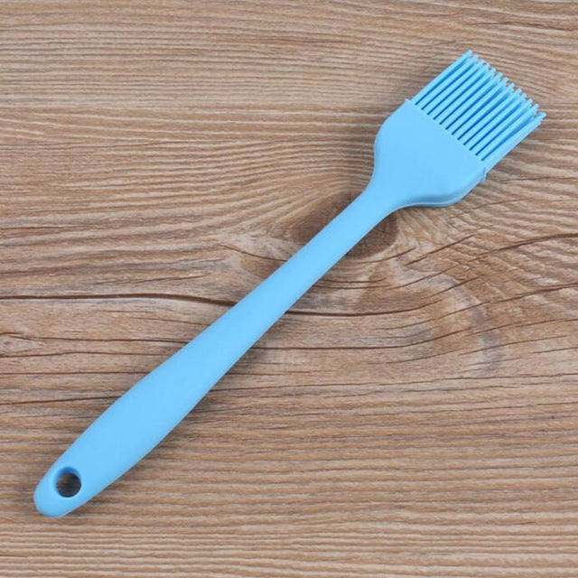 Light blue silicone oil basting brush with fan bristle head and hanging hole handle.